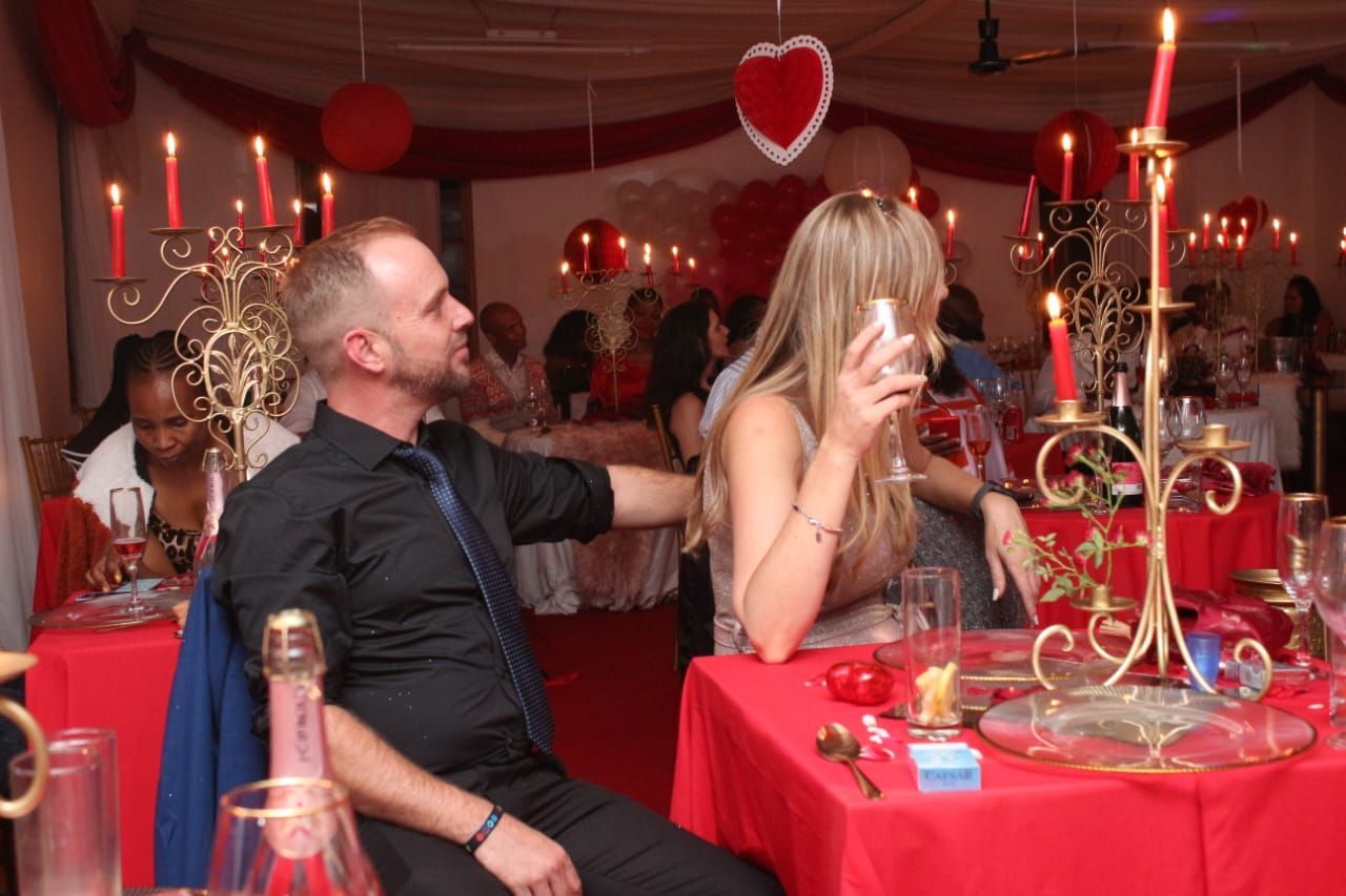 A man and a woman are sitting at a table with candles.