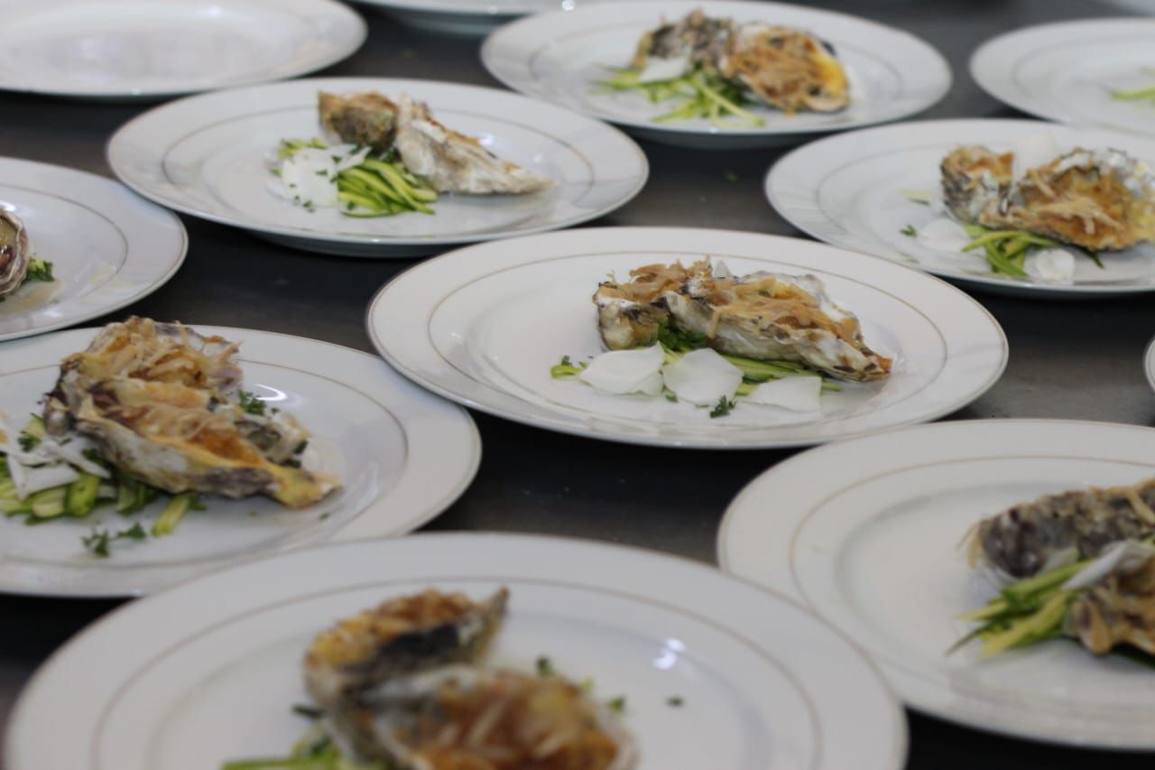 A bunch of white plates with food on them