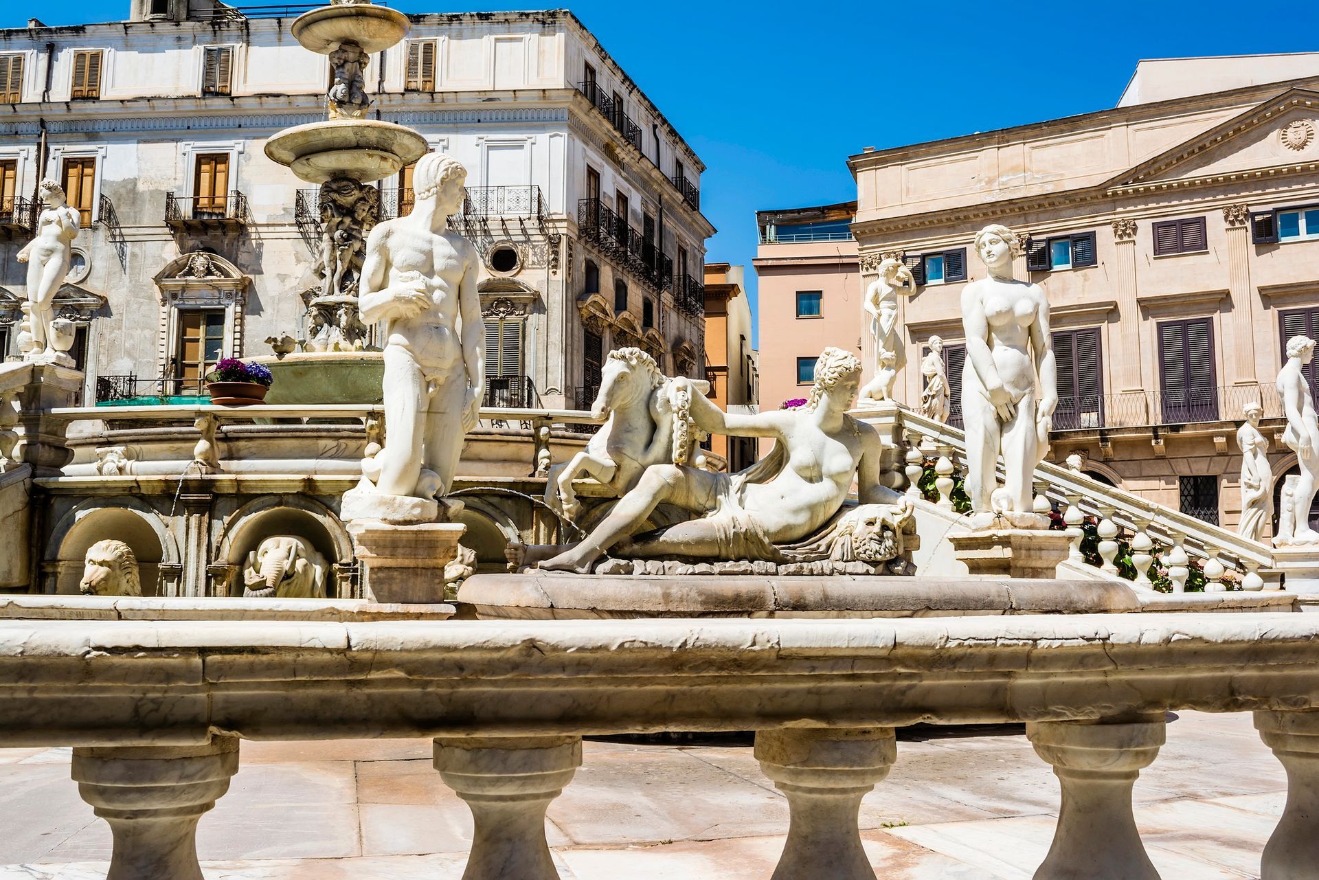 La sontuosa Fontana della Vergogna in Piazza Pretoria a Palermo, con le sue statue di marmo sullo sfondo di edifici storici.