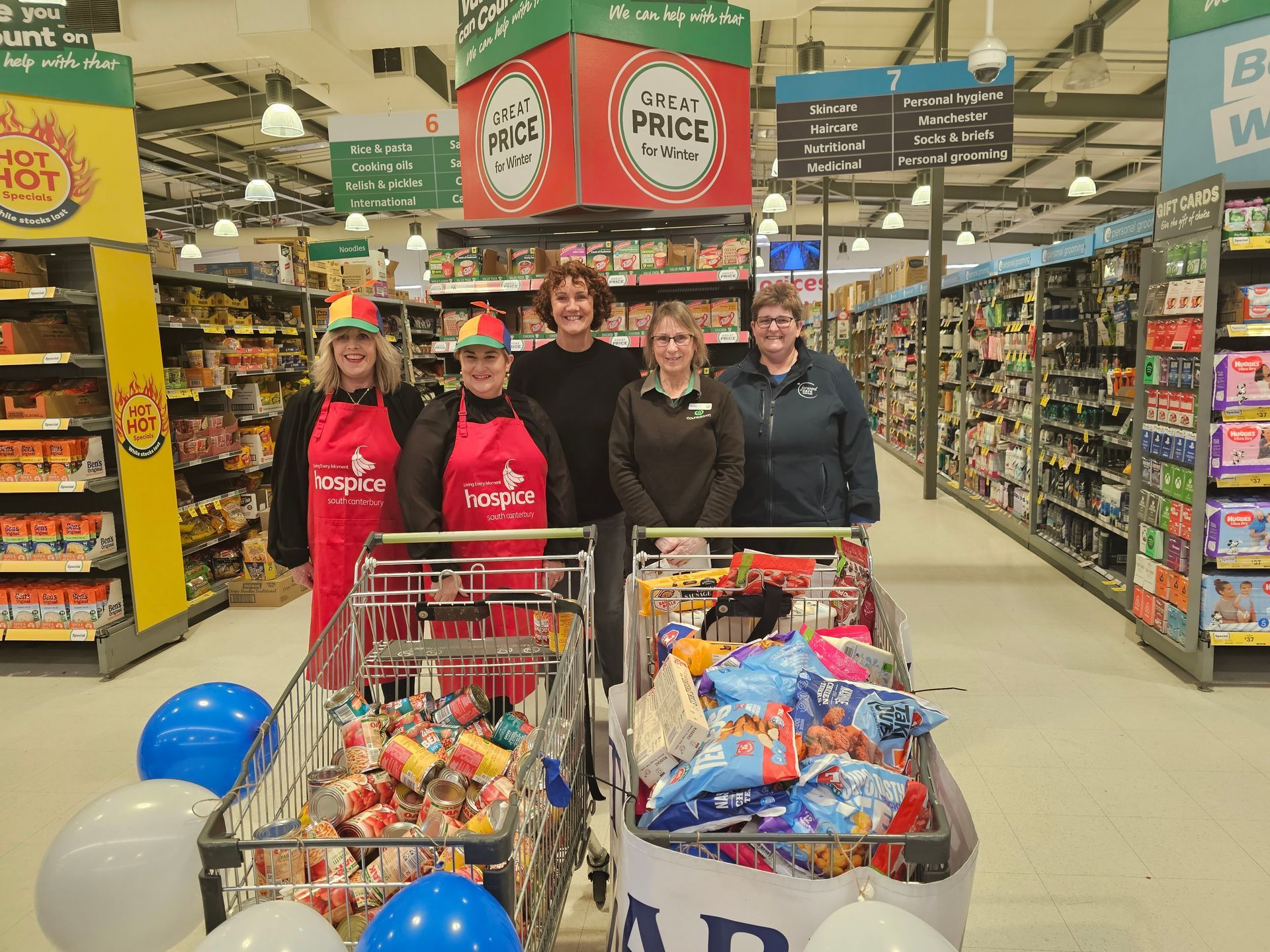A group of people are standing in a grocery store.