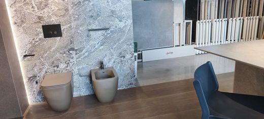 Lavabo da bagno moderno bianco con rubinetto cromato e acqua corrente.