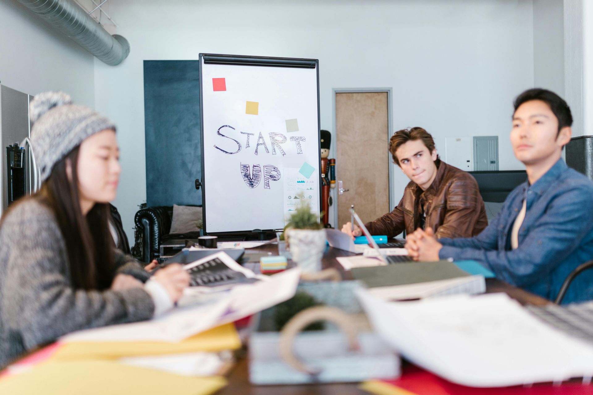 People gathered around a table in a bright meeting room, with a whiteboard labeled “STARS” in the background.