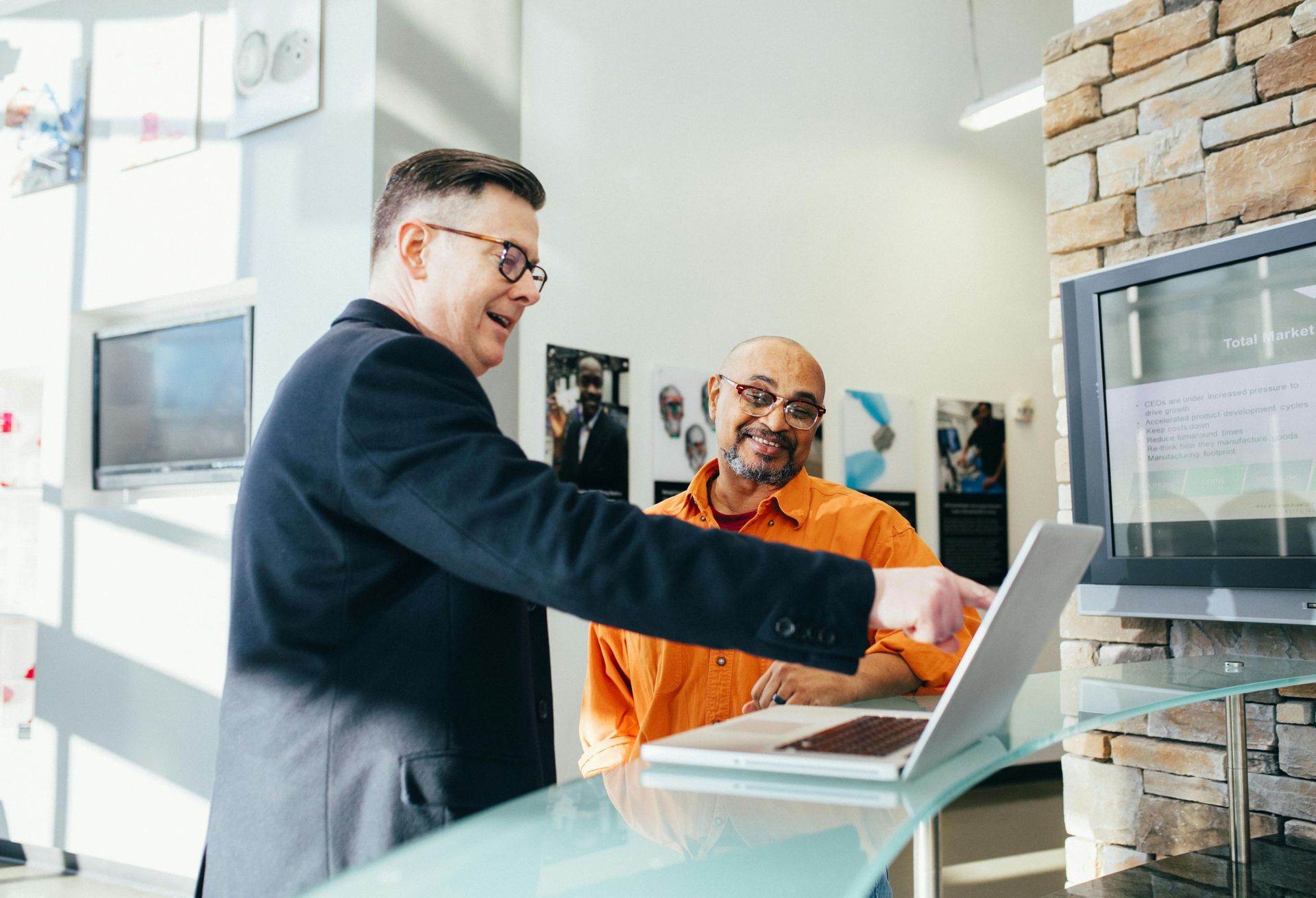 An accountant in Ipswich discussing financial data with a new business owner on laptop.