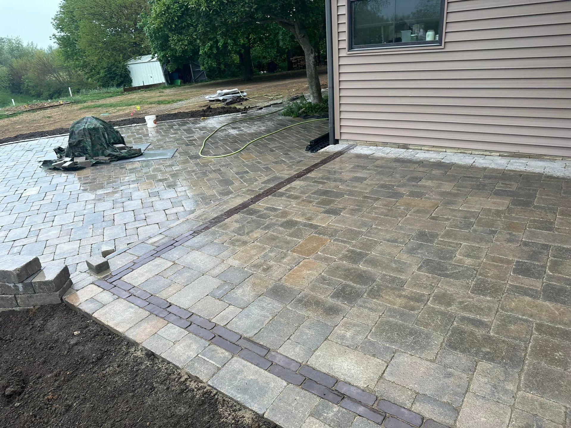 A patio is being built in front of a house.
