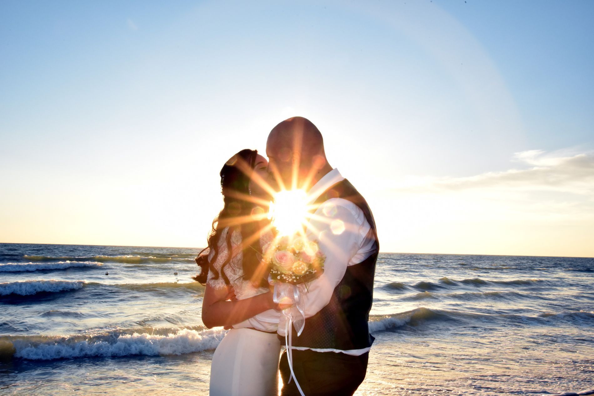 sposi durante un bacio al tramonto