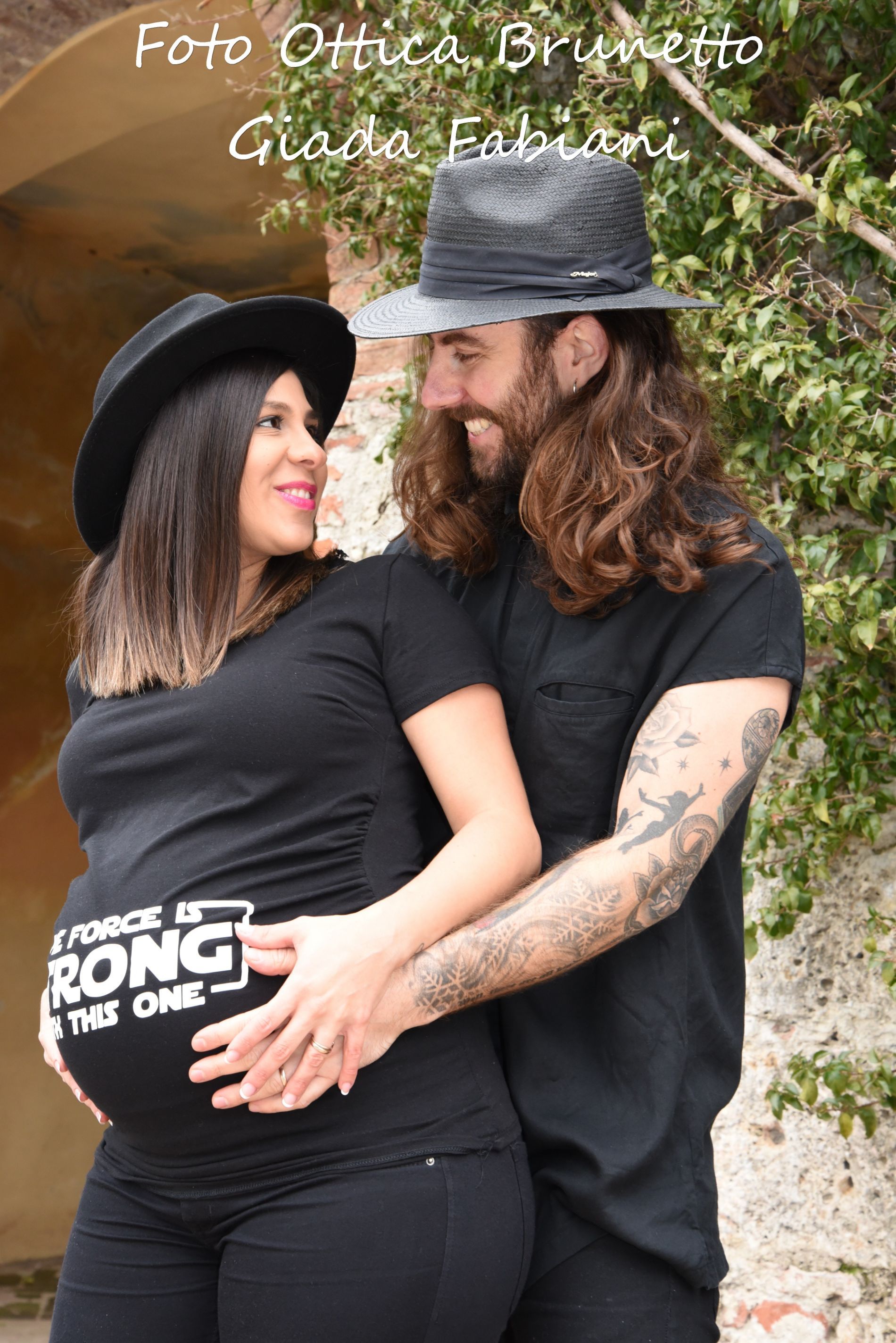 papà abbraccia la moglie con pancione