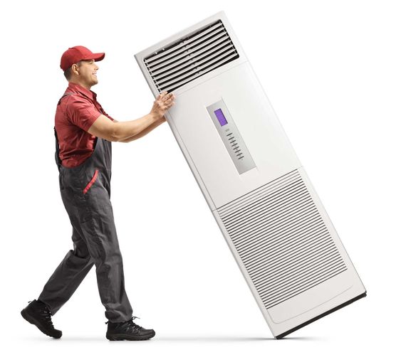 A man is carrying a very large air conditioner.