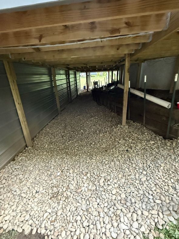 A person doing a handstand on a yellow excavator at a construction site under a cloudy sky.