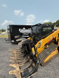White ranch-style house with black trim and a concrete driveway. Green grass and trees surround the property.