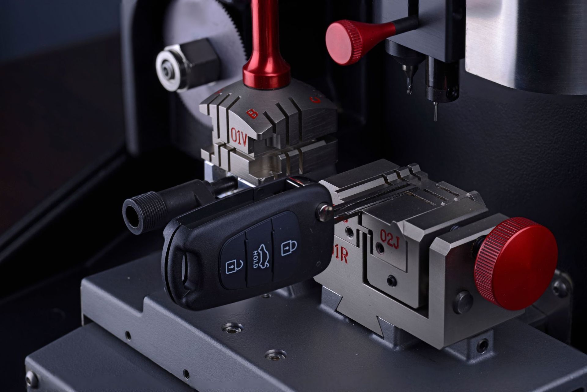 Woman in straw hat smiles, holding wine glass near a lake.