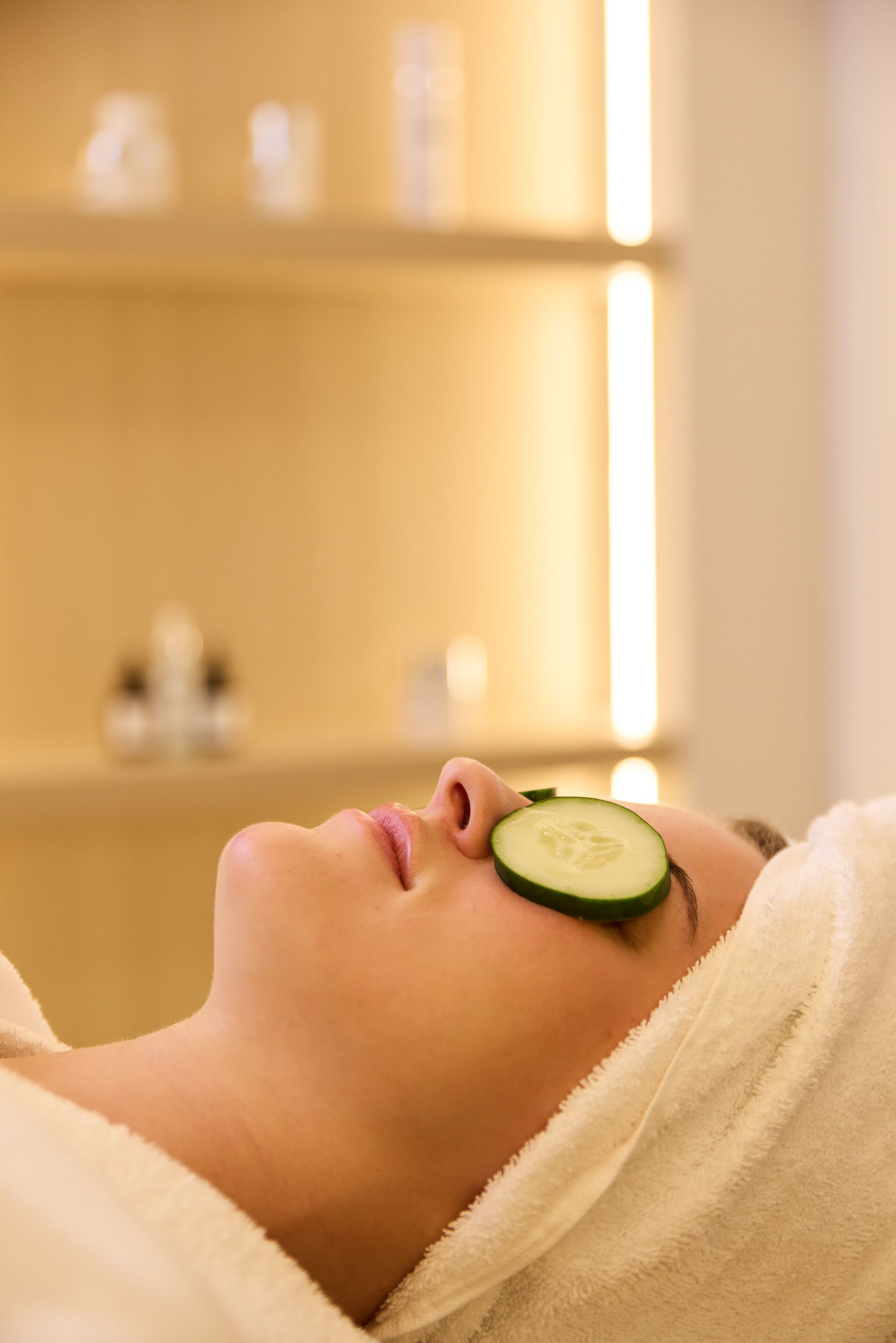 Two women in white robes are holding cups of coffee and smiling