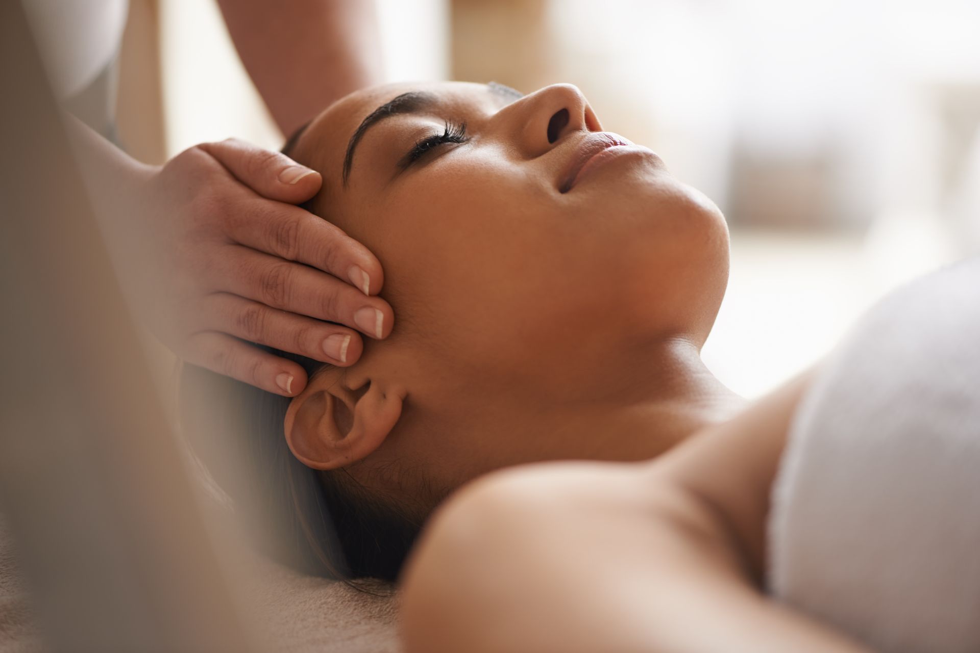 A woman is getting a head massage at a spa.