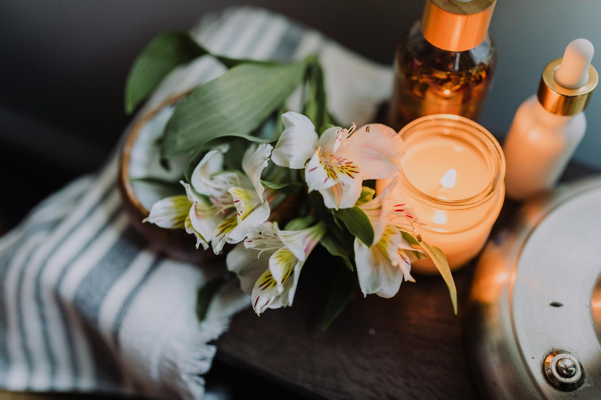 Table with towels, flowers, candles, and lotion for spa treatment