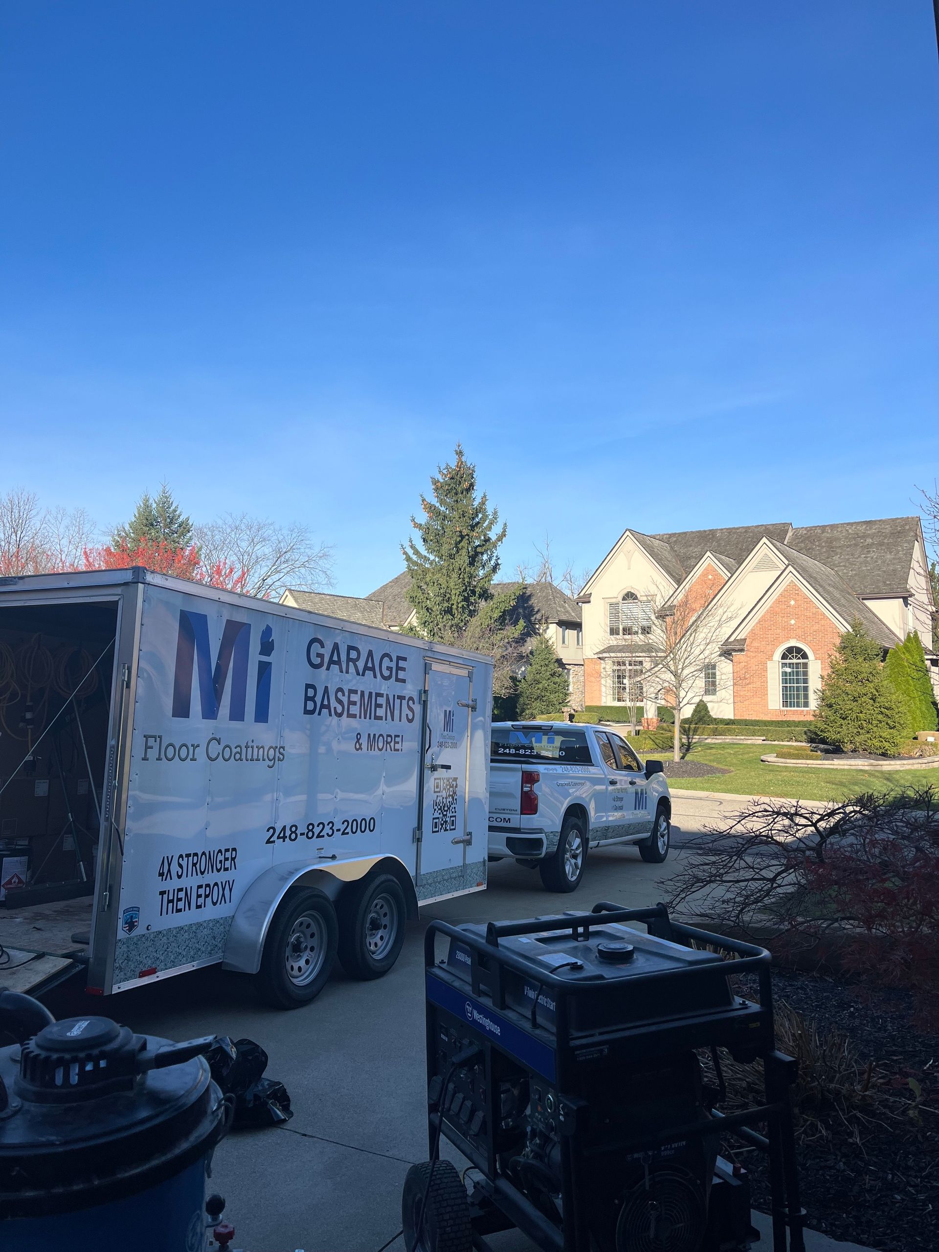 A truck and trailer are parked in front of a house.