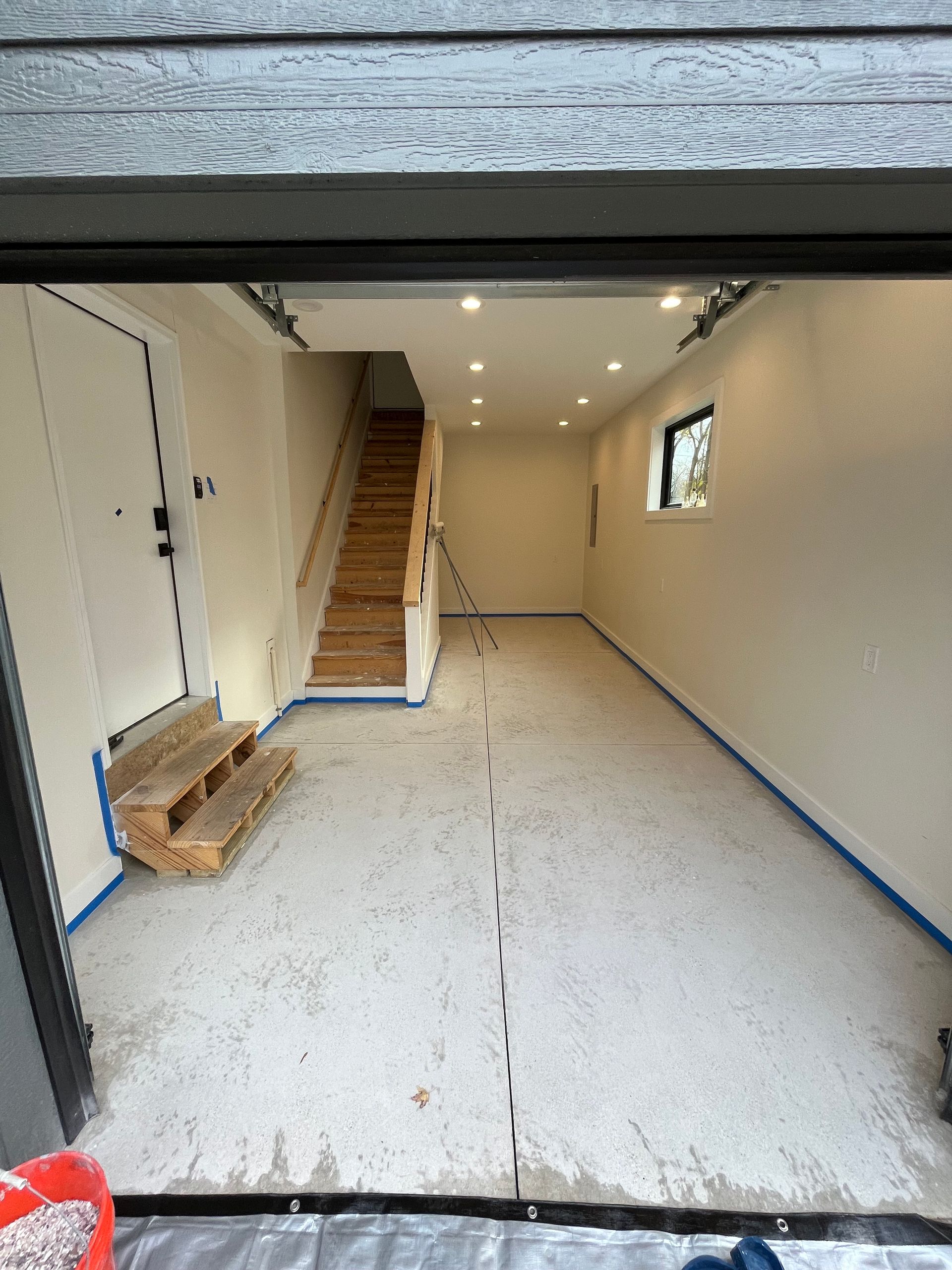 An empty garage with stairs and a window