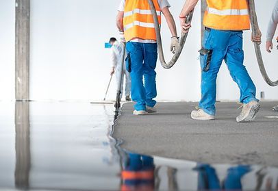 A group of construction workers are walking on a wet floor.