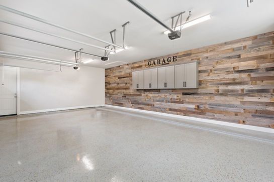 A garage with a wooden wall and a concrete floor.