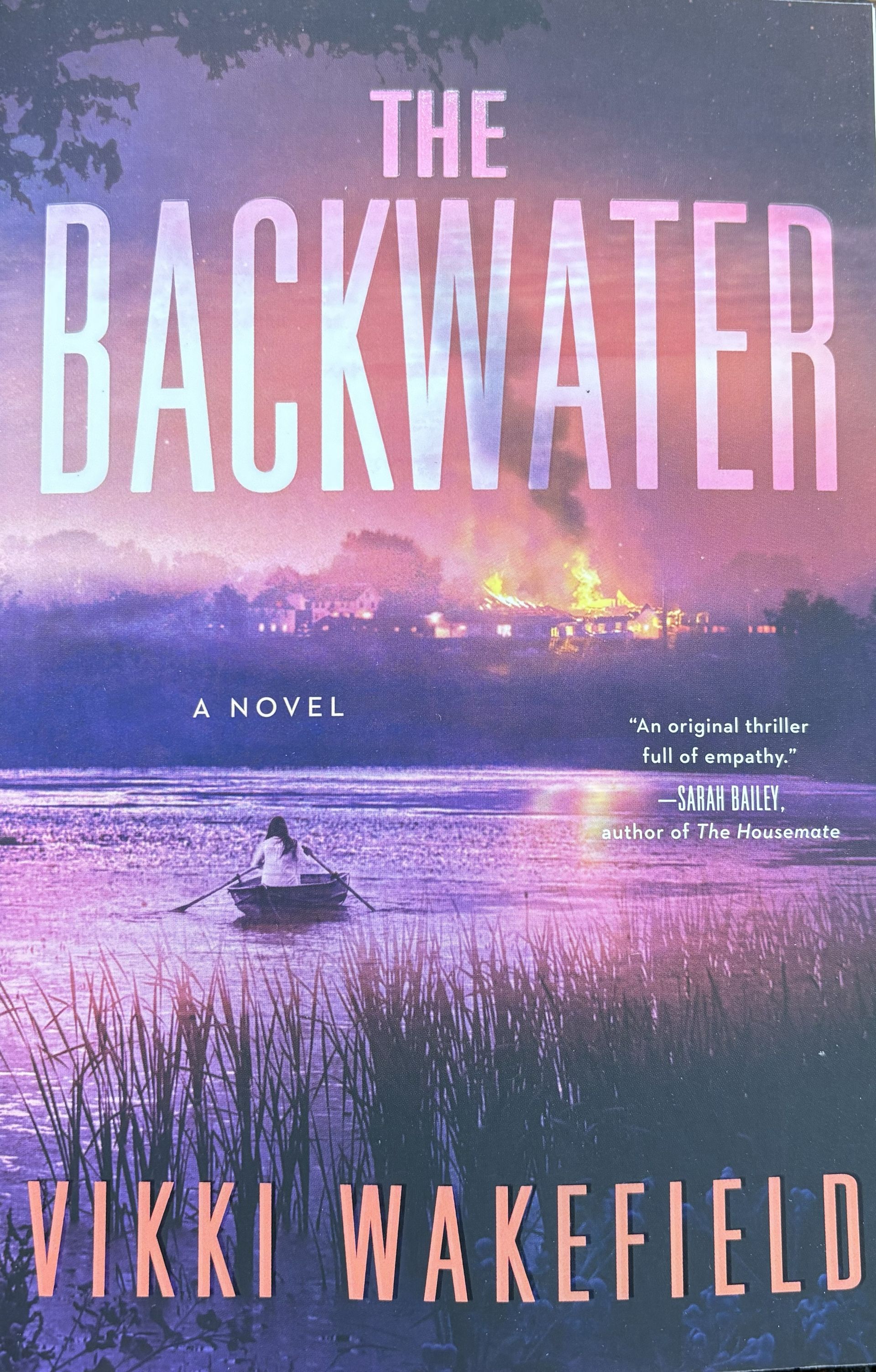 Cover shows a woman in canoe with pink and purple background.  "The Backwater" by Vikki Wakefield.