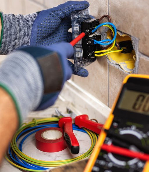 Electrician at work with safety equipment on a residential electrical system. Electricity