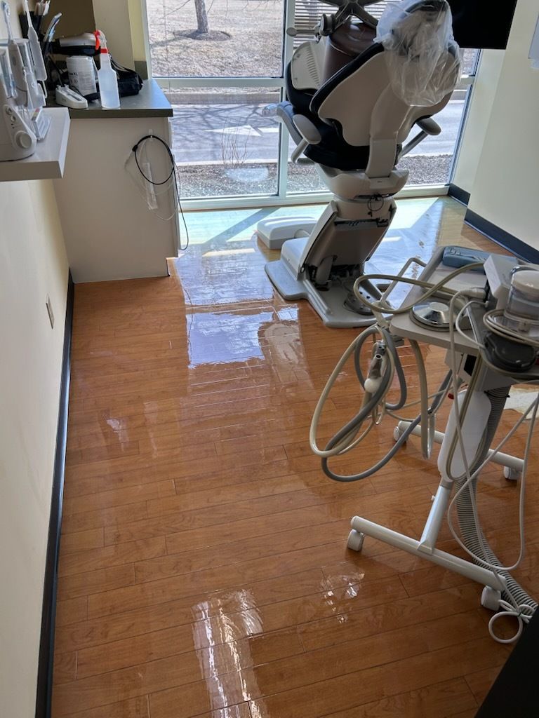 An empty gym with a basketball hoop in the middle