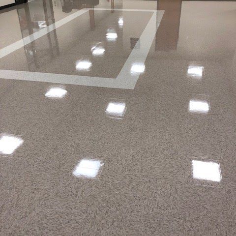 A shiny floor with square lights on it in a room.