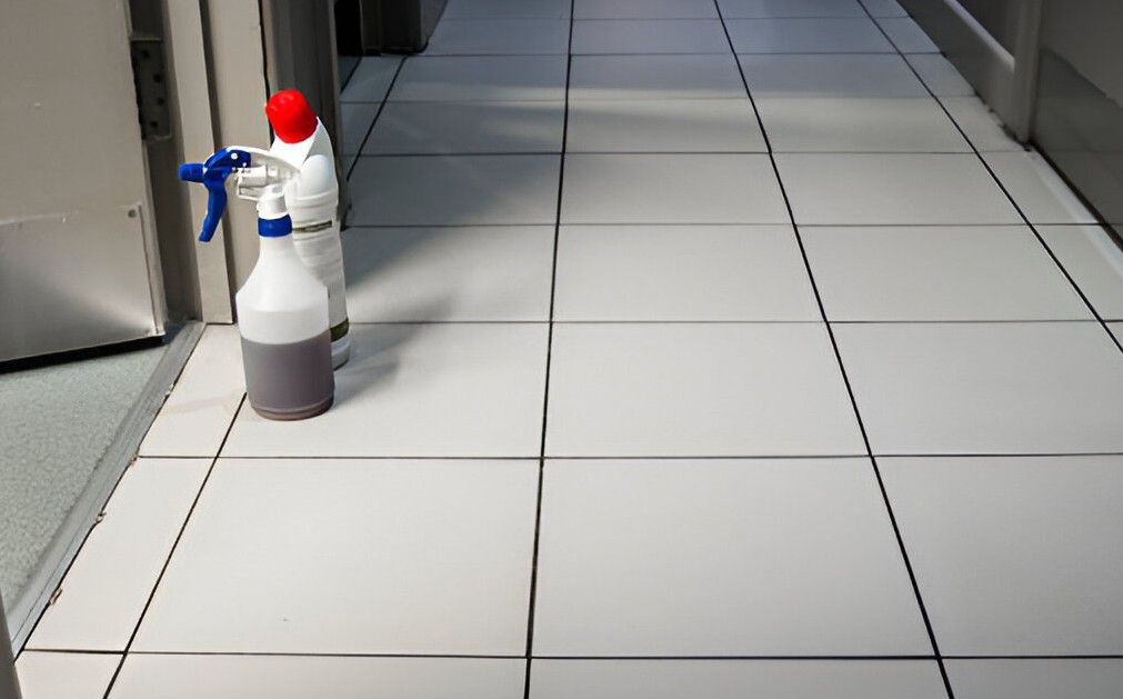 A spray bottle is sitting on a tiled floor in a hallway