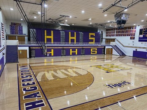 A large gymnasium with a basketball court and a basketball hoop.