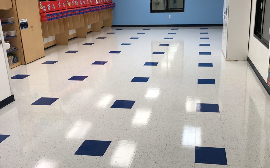 Glossy white floor with blue square tiles in a room with blue walls, and storage units.
