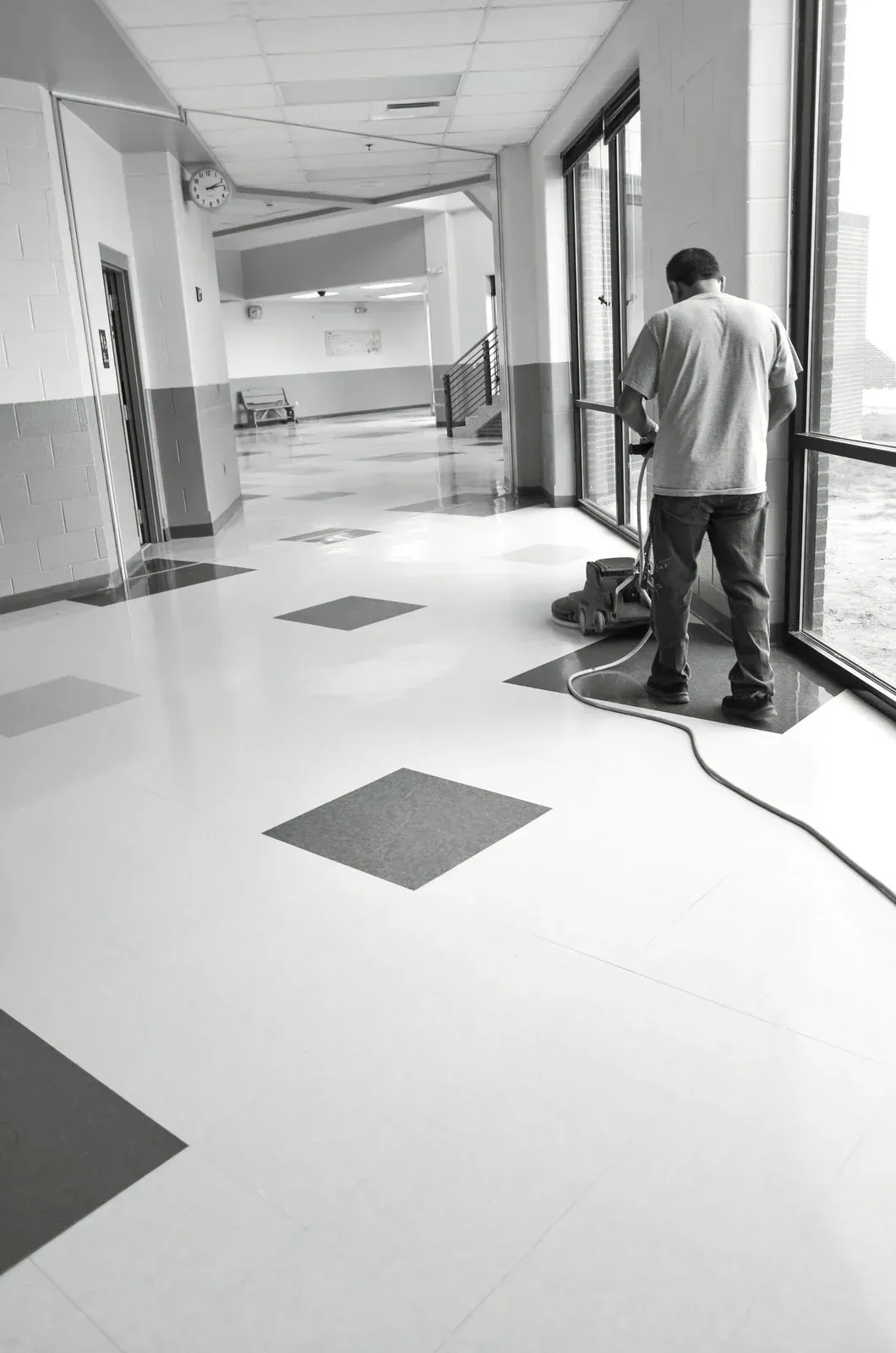 A machine is cleaning a marble floor with a geometric pattern.
