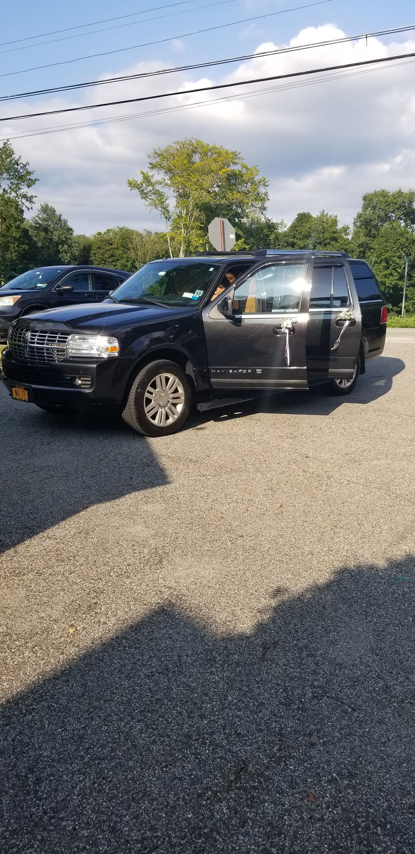 A black ford escape is parked in a gravel lot.