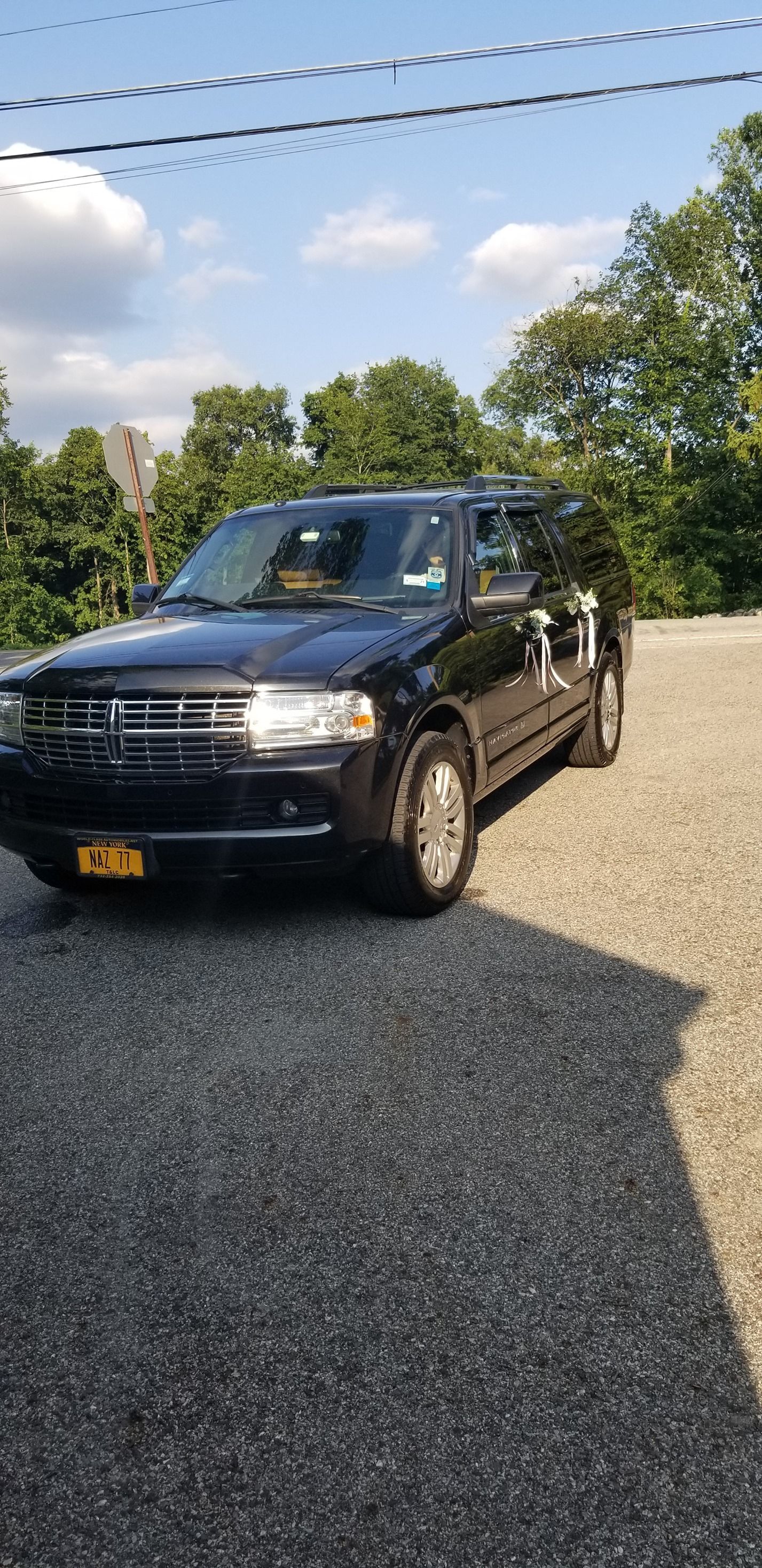 A black ford escape is parked in a gravel lot.