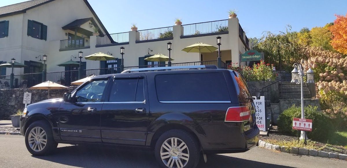 A black suv is parked in front of a building.