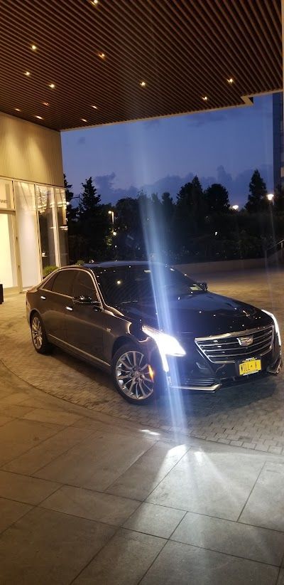 A black car is parked in front of a building at night.
