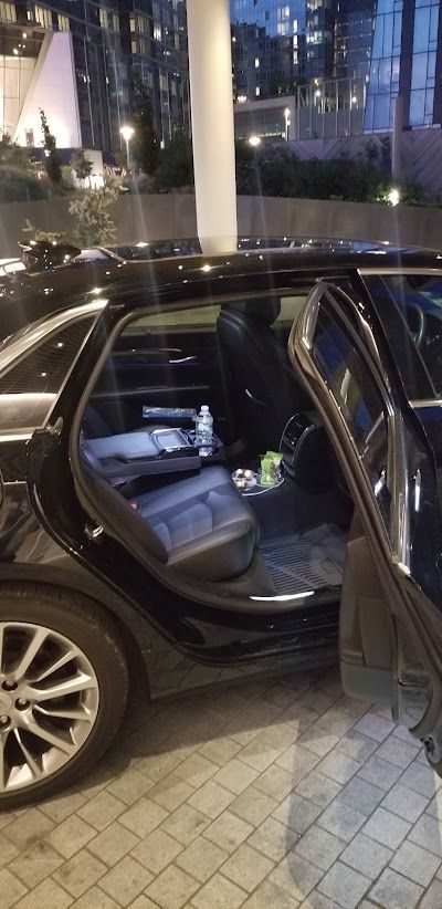 The back seat of a black car with the door open.