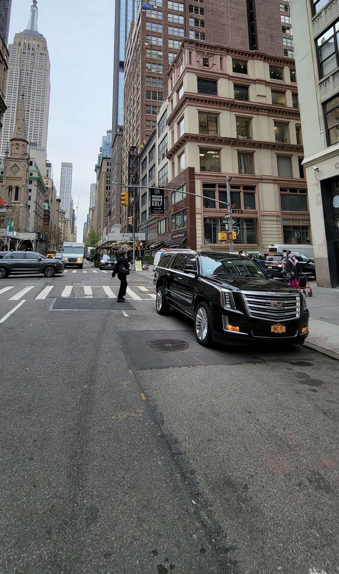 A black car is parked on the side of a city street.