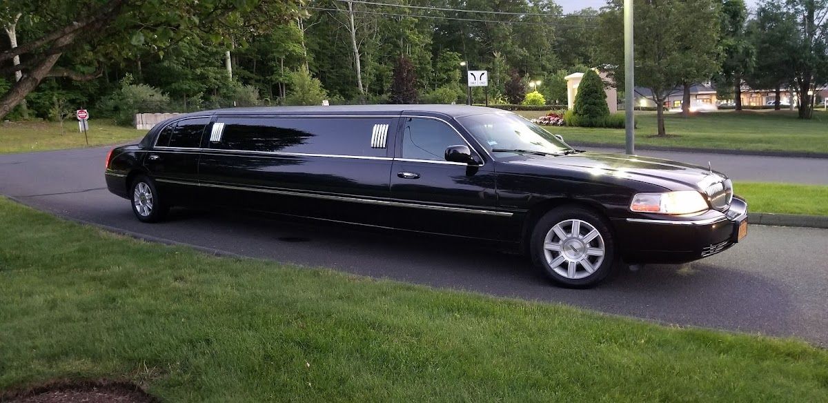 A black limousine is parked on the side of the road.