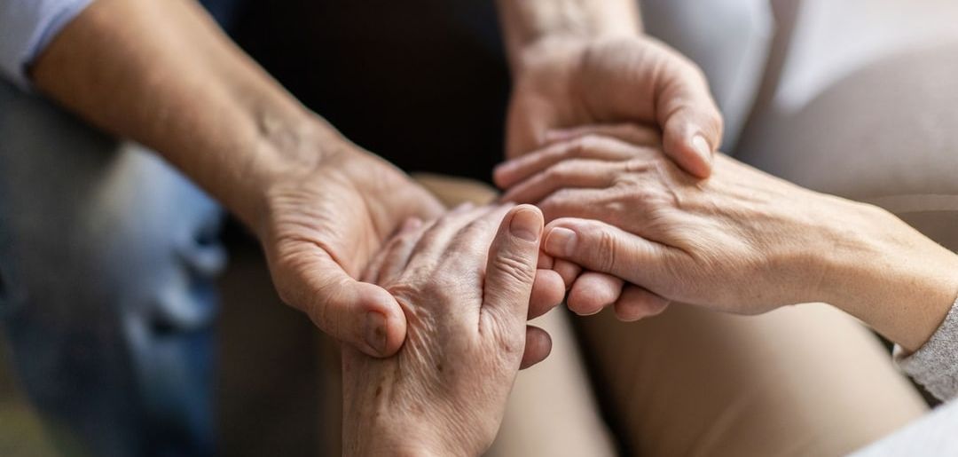 a man and a woman are holding hands while sitting on a couch .