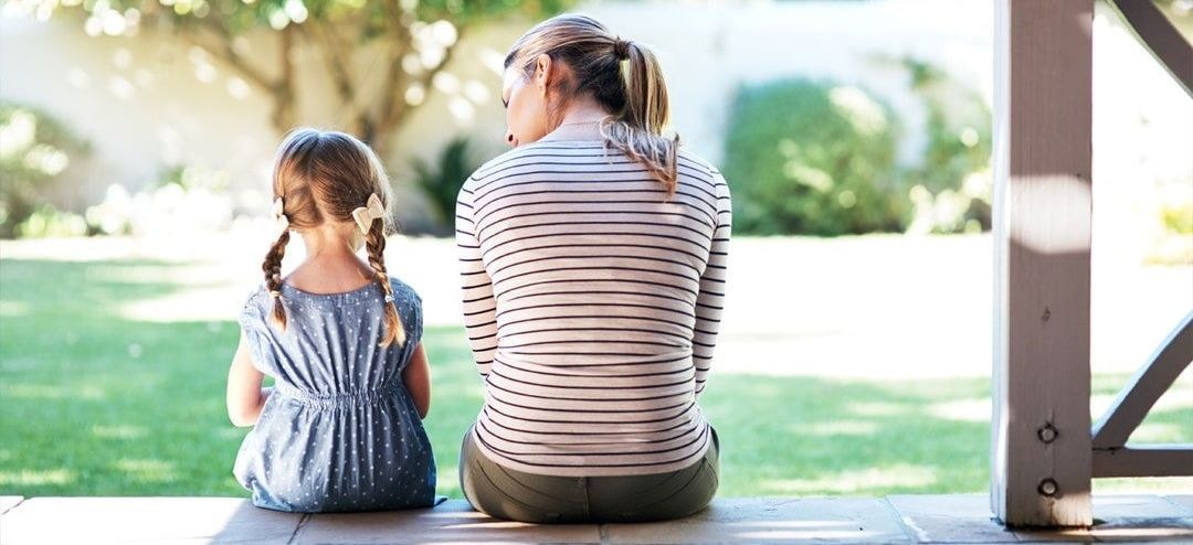 a woman and a little girl are sitting on a porch .