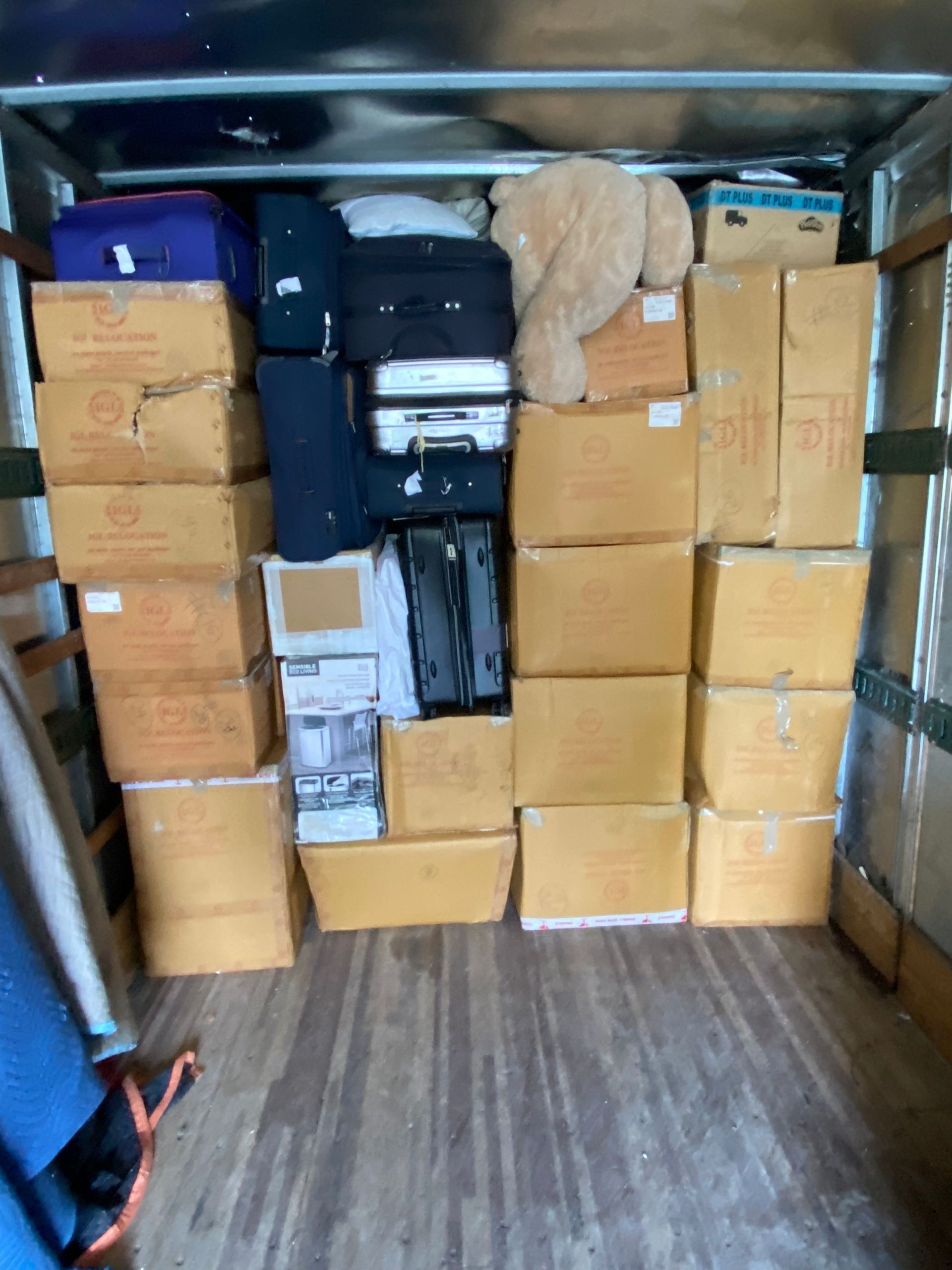 Boxes and luggage fill a truck cargo area.