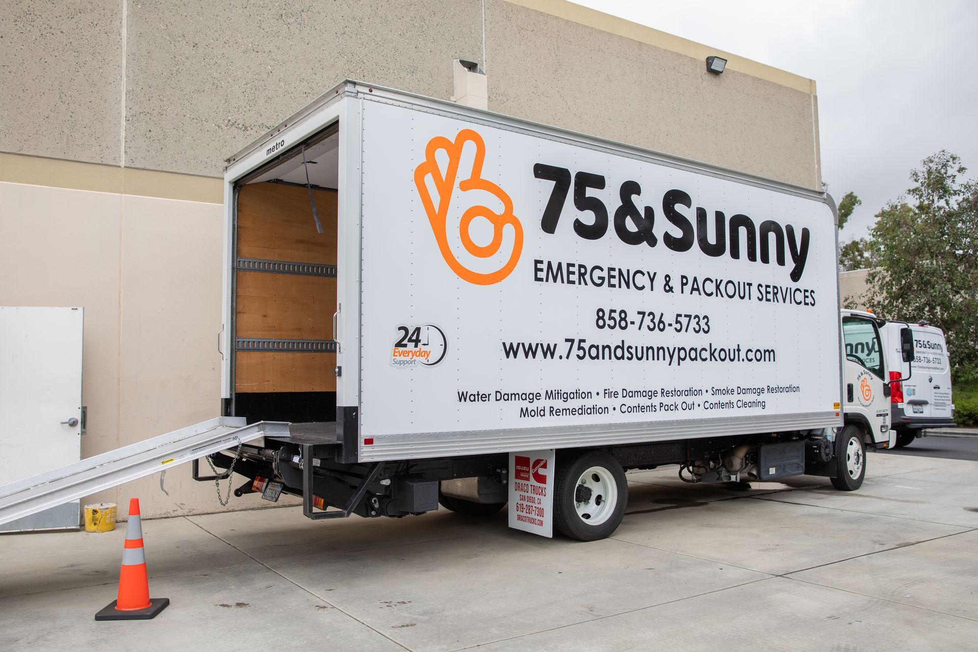 A 75 & sunny truck is parked in a parking lot