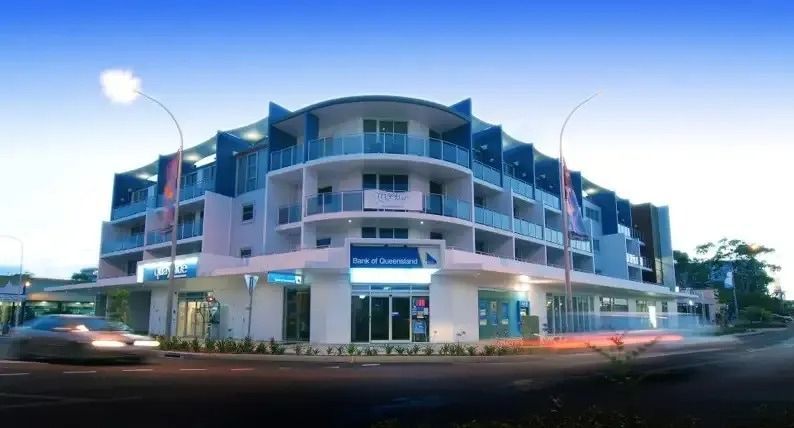 A Large Building With A Lot Of Balconies Is On The Corner Of A Street — Greg Keft Electrical in Port Macquarie, NSW