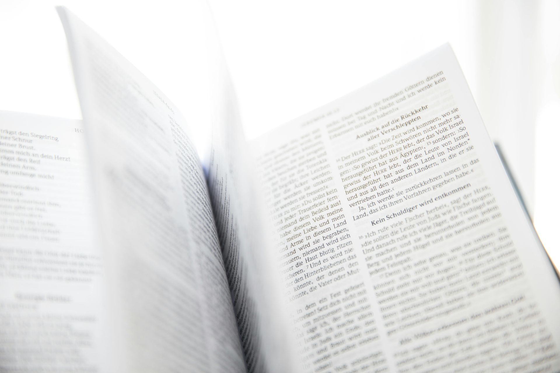 Open book with text, white pages, blurred background.