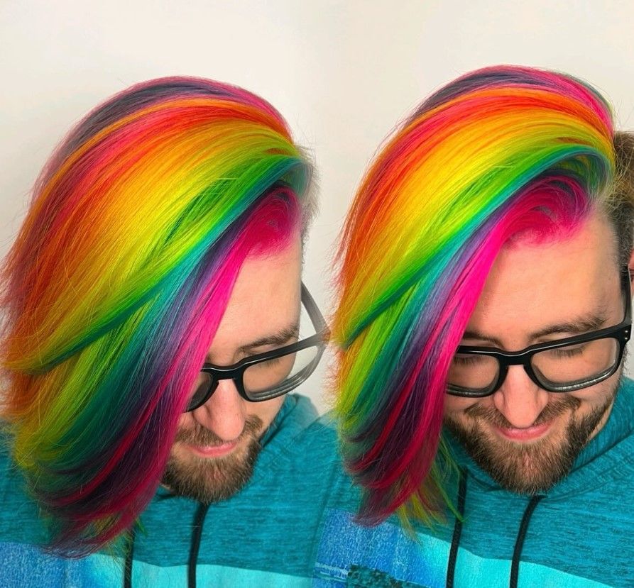 A man with a beard and glasses has rainbow hair.