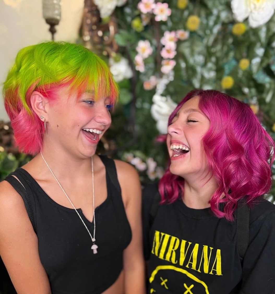 Two girls are laughing and one is wearing a nirvana shirt