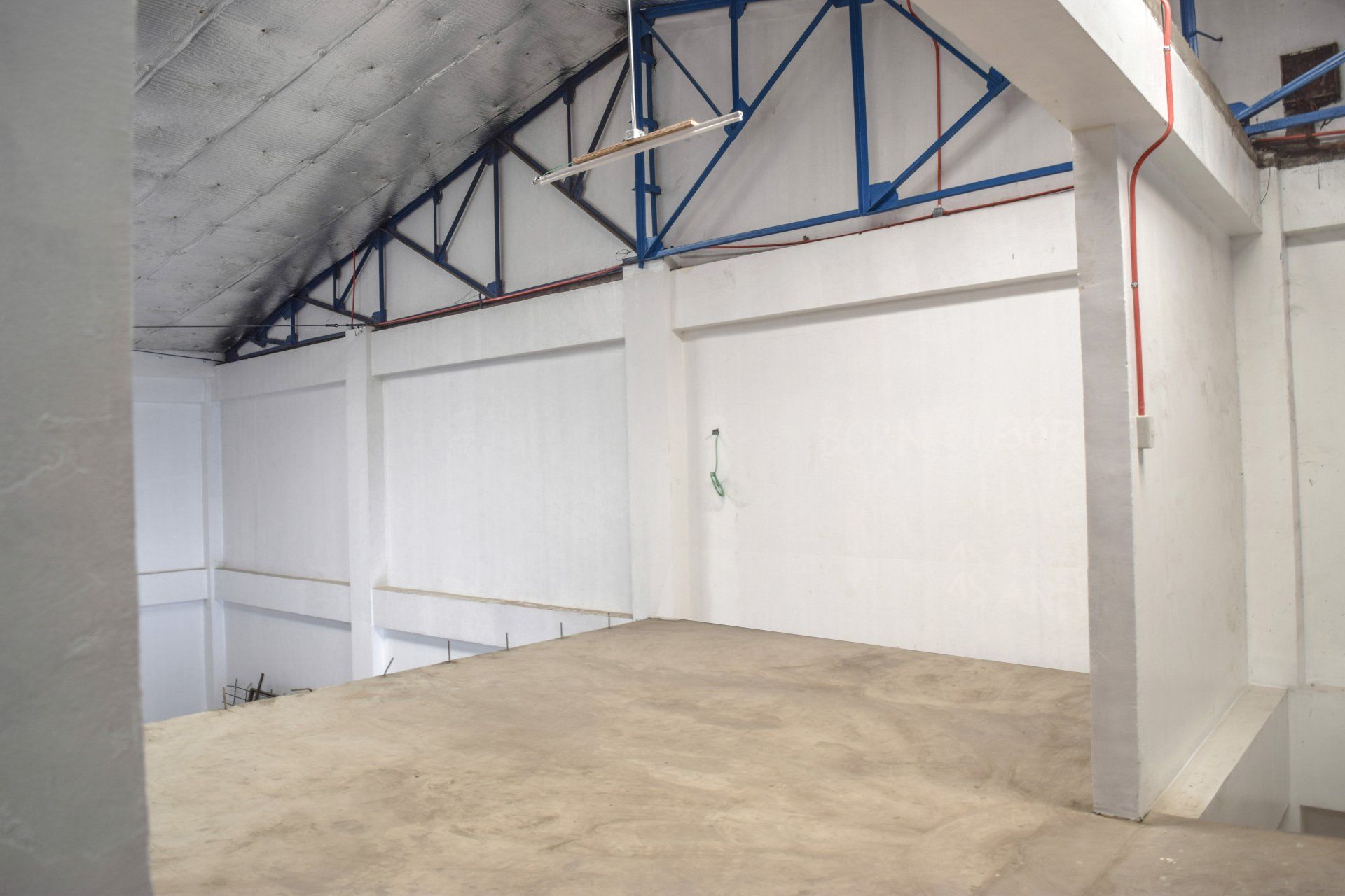 An empty warehouse with white walls and blue beams