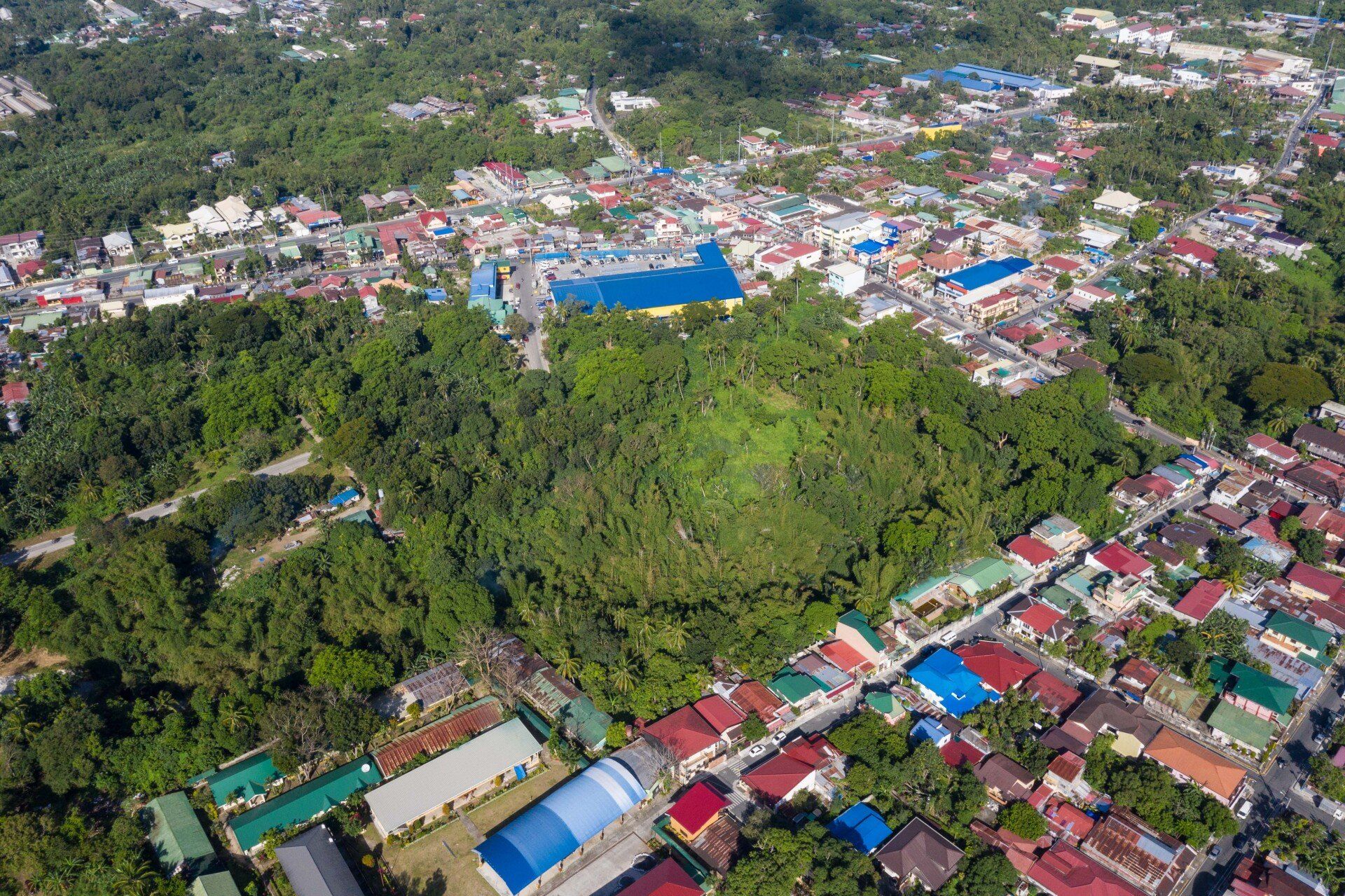 An aerial view of a city surrounded by trees and houses.