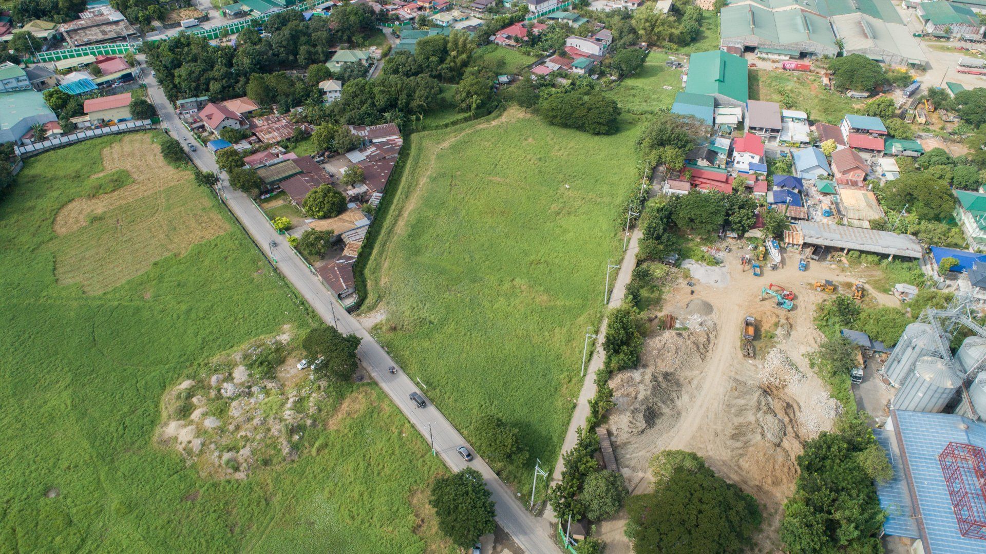An aerial view of a residential area with a road going through it.