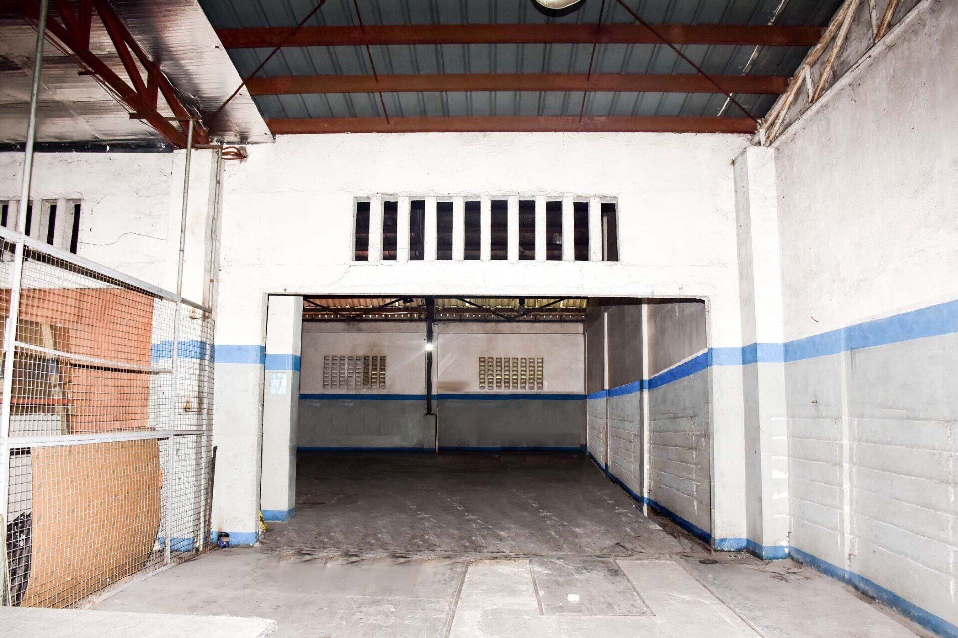 An empty garage with blue and white stripes on the walls