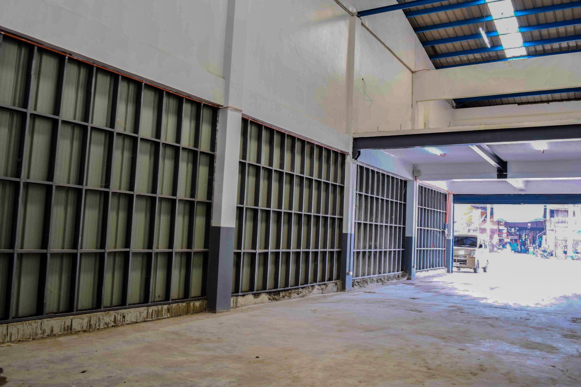 A large empty warehouse with a lot of shelves and a roof.