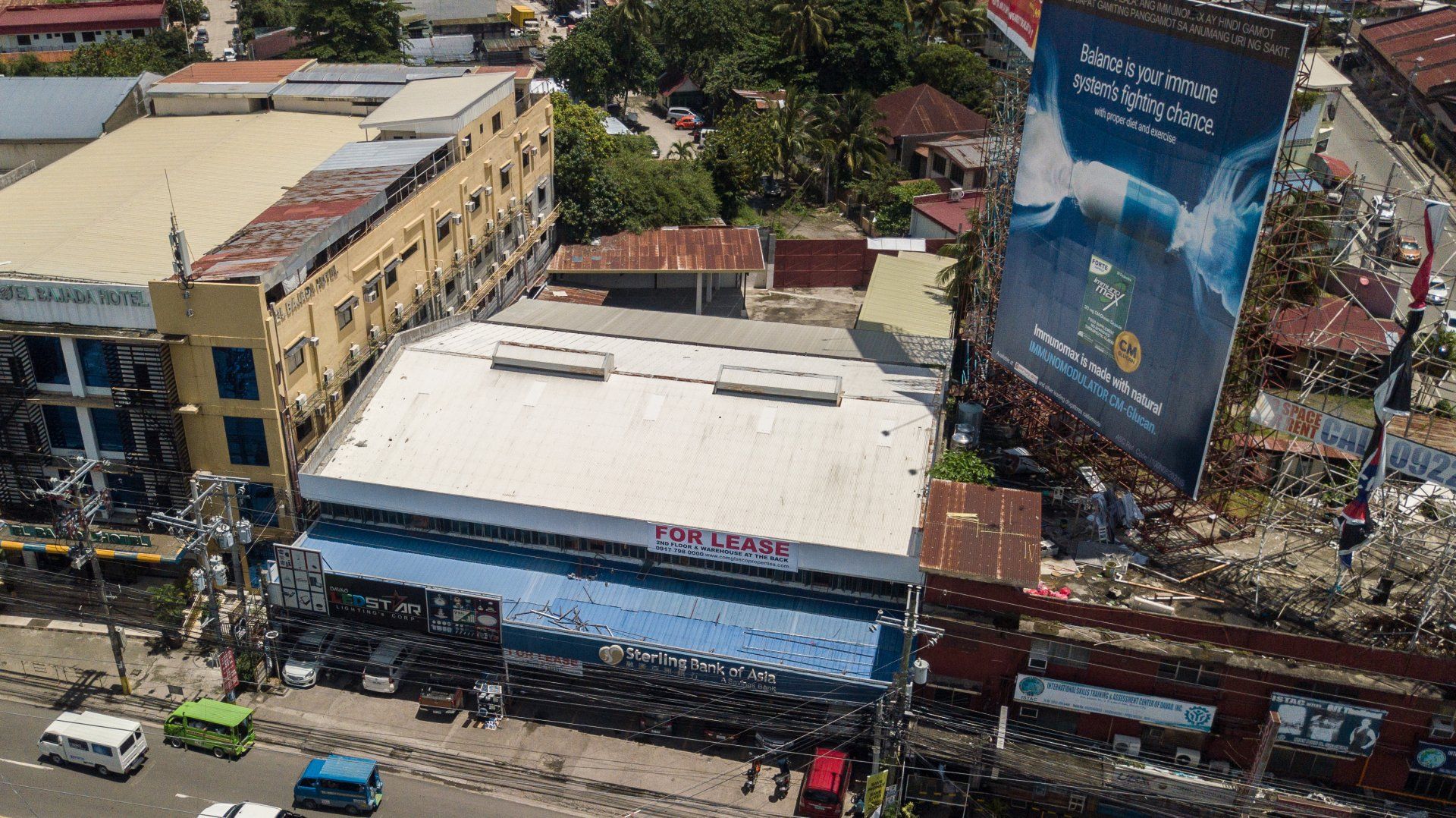 An aerial view of a city with a large billboard on the side of a building.